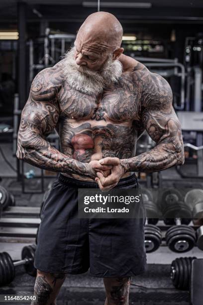 tattooed senior man during gym workout - handsome bodybuilders stock pictures, royalty-free photos & images
