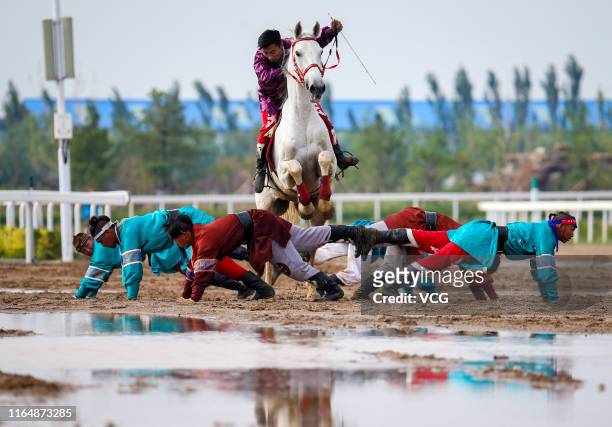 Men perform horse riding skills during the 6th Inner Mongolia International Equestrian Festival on July 27, 2019 in Hohhot, Inner Mongolia Autonomous...