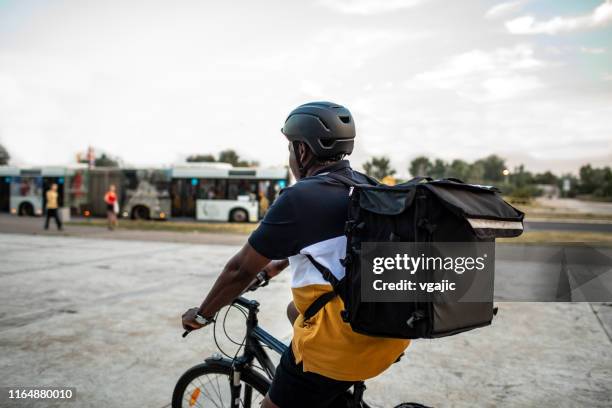 senior african delivery man riding bicycle in the city - bike messenger stock pictures, royalty-free photos & images