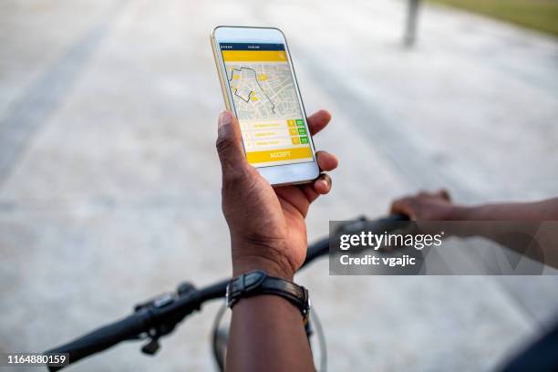 Senior African Delivery Man Checking Mobile App for Direction in the City