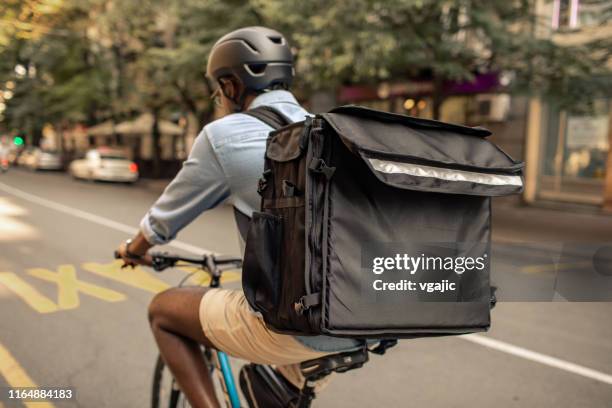 junge afrikanische liefermann fahrrad in der stadt fahren - fahrradkurier stock-fotos und bilder