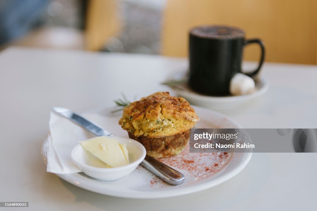 Scone made with native Australian ingredients, served with butter and hot chocolate on a table