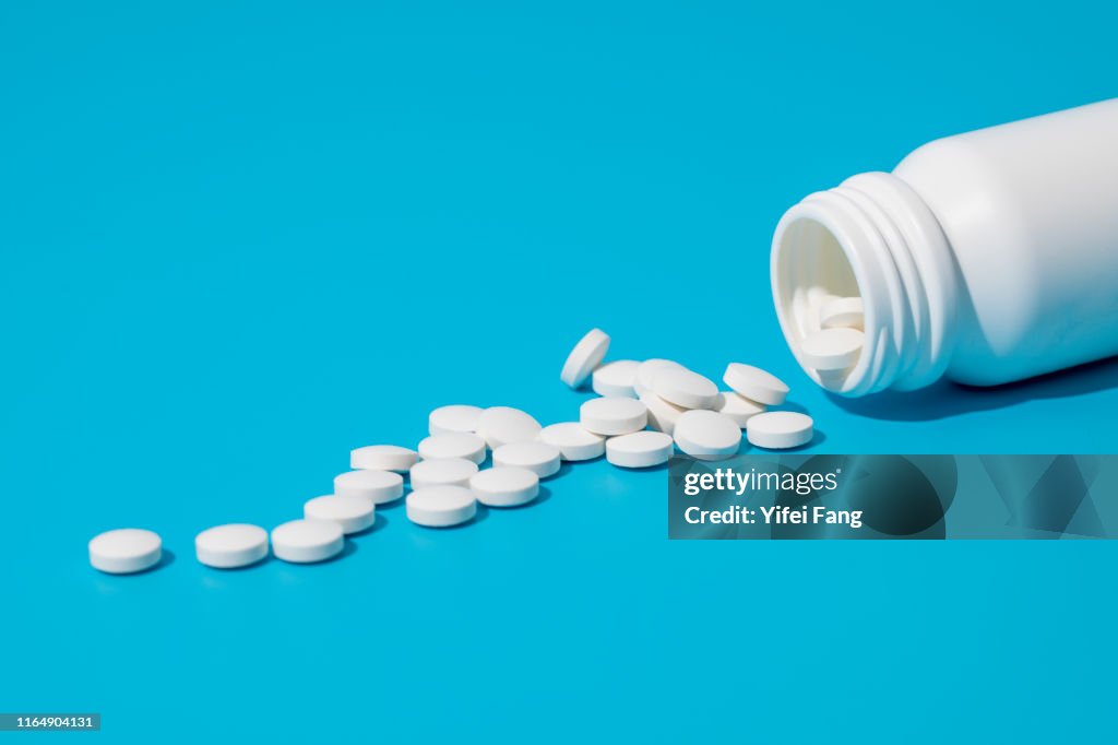 White pills spill out of pill bottle