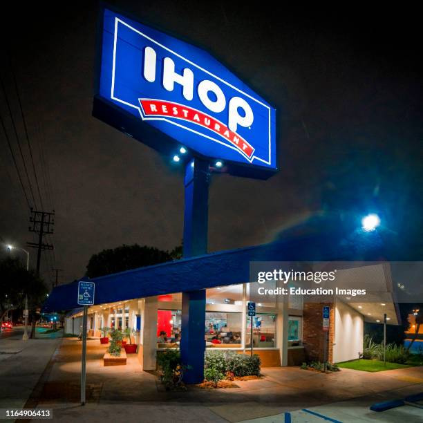 Edward Hopper style view of Los Angeles California IHOP at night with neon sign on.