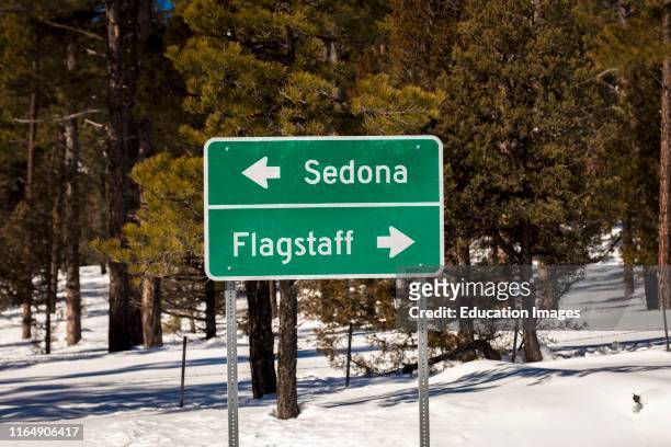 Americana Roadside America shows Sign to Flagstaff and Sedona in snow.