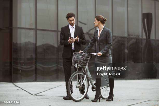 zaken paar voor het kantoor - partnership men bikes stockfoto's en -beelden