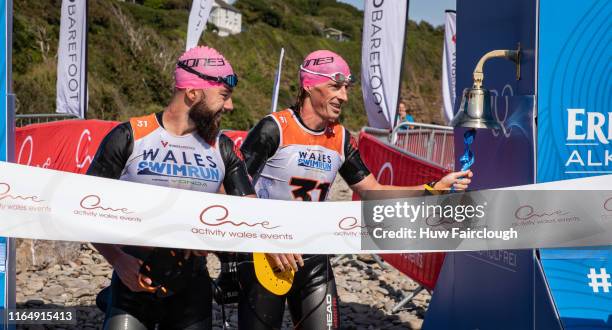 Alexis Charrier and Nicolas Remires finish the race and ring the bell to signify finishing the race in the Wales SwimRun race through Pembrokeshire,...