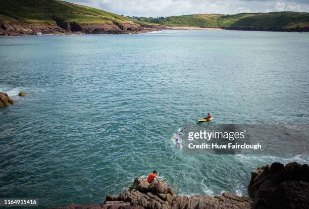 Alexis Charrier and Nicolas Remires swim from the cliff towards Manobier beach during the Wales SwimRun race through Pembrokeshire, starting in...