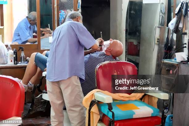 Colombia, Cartagena, Customer getting shave in barbershop.