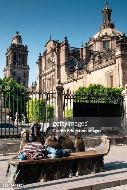 Man sleeping on a bench with figures, Mexico City, Mexico;.