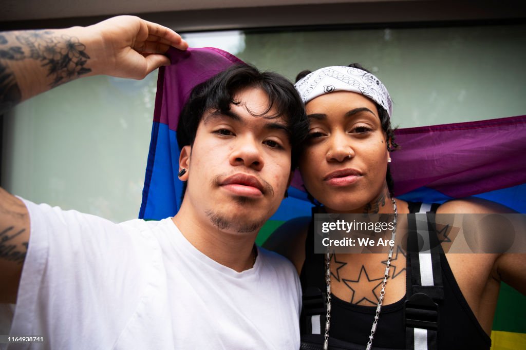 Two friends wrapped in pride flags