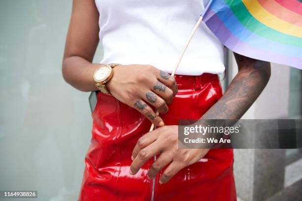 close up of woman holding rainbow flag - pride london stock pictures, royalty-free photos & images