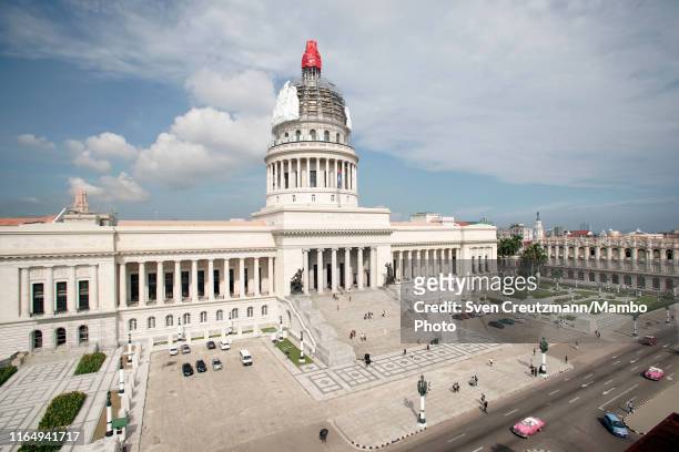 Workers unveil the cover of the dome of El Capitolio, the National Capitol Building, on August 30 in Havana, Cuba. The Capitolio, which will host the...