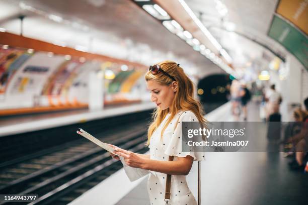 jeune femme de touriste dans la station de métro de paris - map paris photos et images de collection
