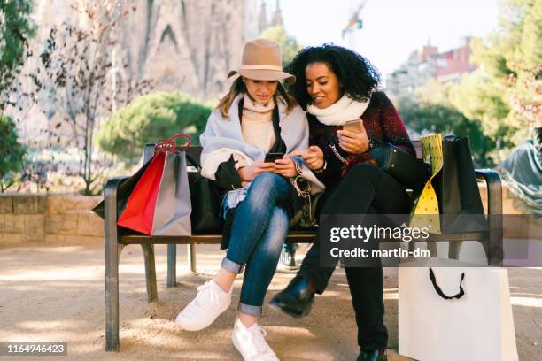 vrienden na het winkelen controleren van sociale media - luxury europe vacation stockfoto's en -beelden