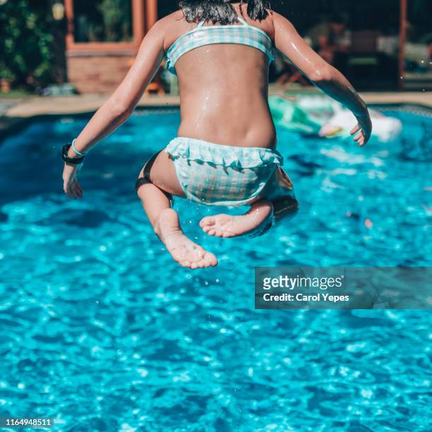 girl jumping into swimming pool - girl diving fotografías e imágenes de stock