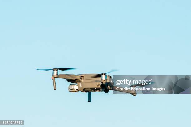 Quadcopter drone flying in the sky over Hunstanton, Norfolk coast, UK.