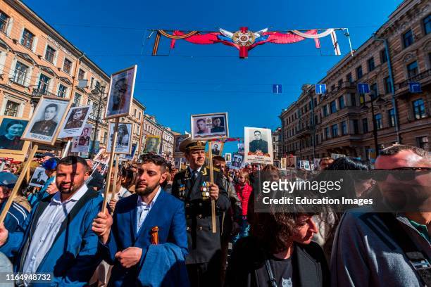 Immortal regiment, people carry banners with a. (Photograph of their warrior ancestors, Victory Day, Nevsky Prospect, St Petersburg, Russia.