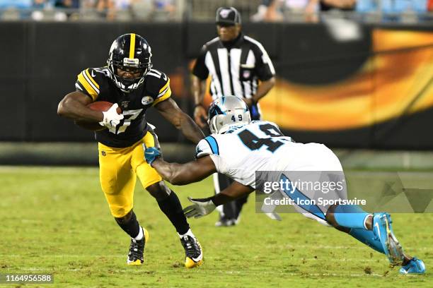 Carolina Panthers linebacker Antwione Williams leaps at Pittsburgh Steelers wide receiver Eli Rogers to attempt a tackle during the preseason game...