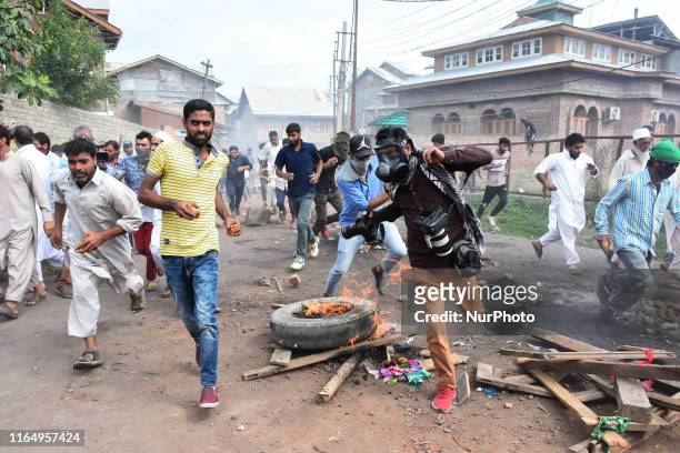Photojournalist runs for cover during clashes between people and Indian Forces in Srinagar, Indian Administered Kashmir on 30 August 2019. Protests...