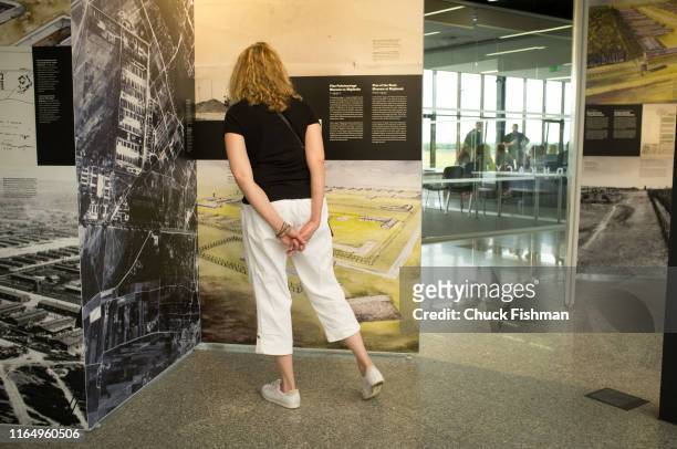 Visitor reads an exhibition display panel in a former concentration camp in the now State Museum at Majdanek, Lublin, Poland, July 6, 2019.