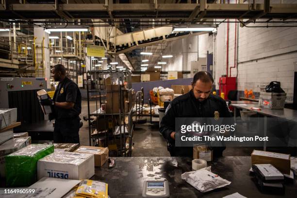 Officer Mohammed Rahman, CBP, holds a bag filled with white powder for testing at the JFK International Mail Facility on Friday, September 7 in...