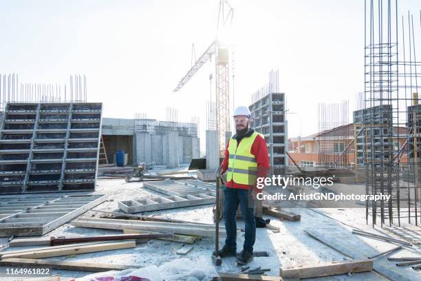 full length portrait von baustelle männlichen arbeiter. - leuchtbekleidung stock-fotos und bilder