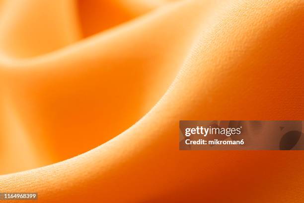 fabric texture background. - orange silk background stock-fotos und bilder