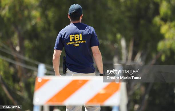 An FBI agent walks toward the site of the Gilroy Garlic Festival after a mass shooting there yesterday on July 29, 2019 in Gilroy, California. Three...