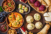 Traditional Georgian cuisine background. Khinkali, phali, chahokhbili, lobio, cheese, eggplant rolls, dark background.