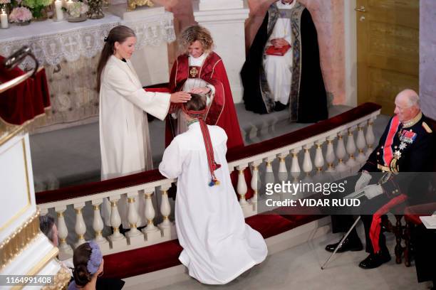 Princess Ingrid Alexandra kneels in front of Vicar Karoline Astrup and Bishop Kari Veiteberg during her confirmation at the Palace Chapel on August...