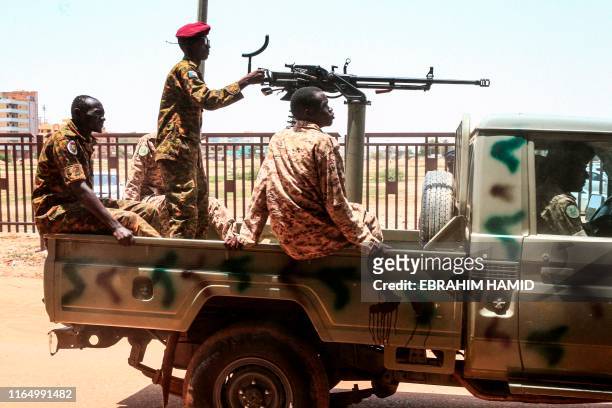 Sudanese army soldiers ride in the back of a technical as they ride in a convoy escorting ex-president Omar al-Bashir back to prison after his...