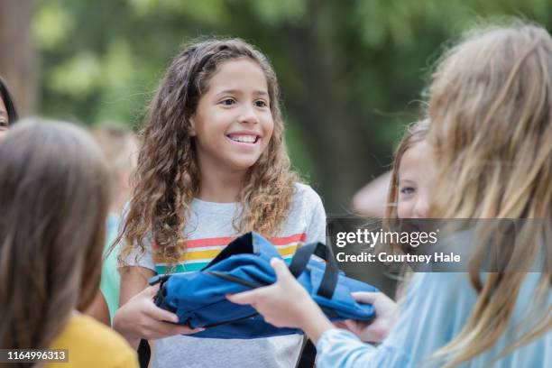 niños voluntarios en la unidad de donación de suministros escolares en la escuela primaria - children charity fotografías e imágenes de stock