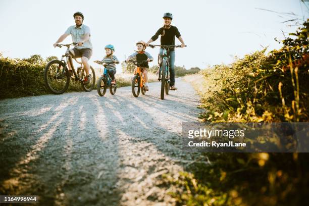 mountain bike in famiglia in sella insieme nella giornata di sole - vita attiva foto e immagini stock