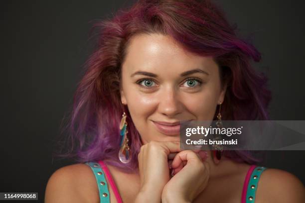 studioporträt einer 30-jährigen frau mit lila haaren auf schwarzem hintergrund - 30 year old female stock-fotos und bilder