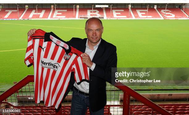 Uwe Rosler holds up his new club's shirt as he is announced as the new manager of Brentford FC, at Griffin Park on June 16, 2011 in Brentford,...