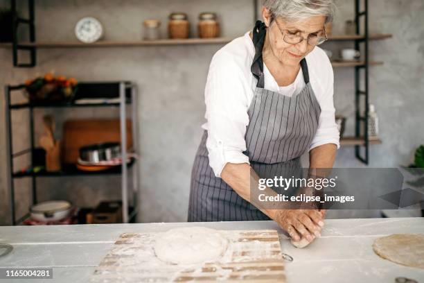 senior kvinna baka en kaka - knåda bildbanksfoton och bilder