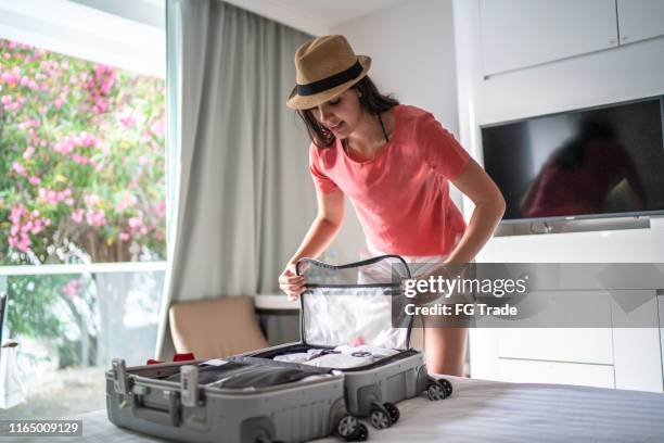 mujer organizando su equipaje en la habitación del hotel - equipaje de mano fotografías e imágenes de stock