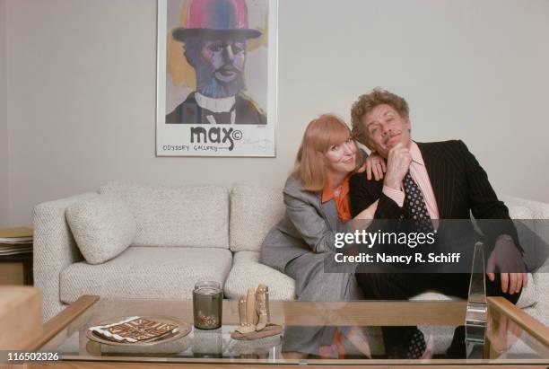 Married comedic actors Anne Meara and Jerry Stiller posing on a living room sofa.