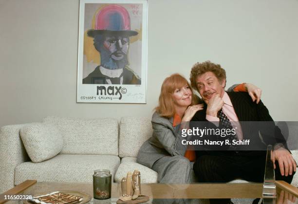 Married comedic actors Anne Meara and Jerry Stiller posing on a living room sofa.