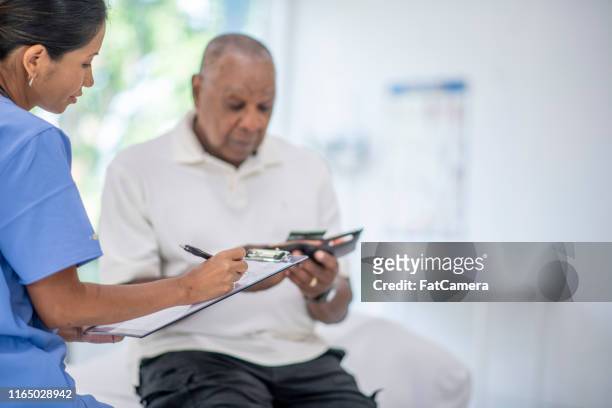 senior adult at medical appointment - paying doctor stock pictures, royalty-free photos & images
