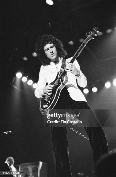 Brian May, guitarist and a songwriter with the British rock band Queen, playing the guitar during a live concert performance by the band at Ahoy Hall...