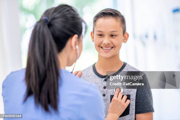 jongen met zijn hartslag gecontroleerd. - fat boys stockfoto's en -beelden