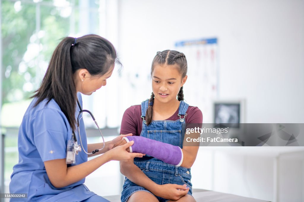 Hispanic girl at medical appointment with a broken arm