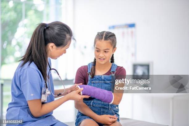 hispanic girl at medical appointment with a broken arm - broken arm stock pictures, royalty-free photos & images