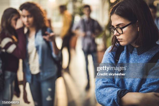 traurige high-school-schüler fühlen sich einsam in einem flur. - bully school stock-fotos und bilder