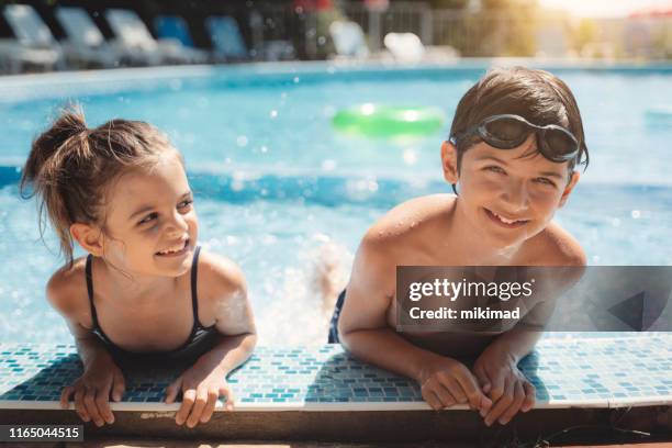 miúdos que jogam na piscina. as crianças nadam. diversão em família. - kids pool games - fotografias e filmes do acervo