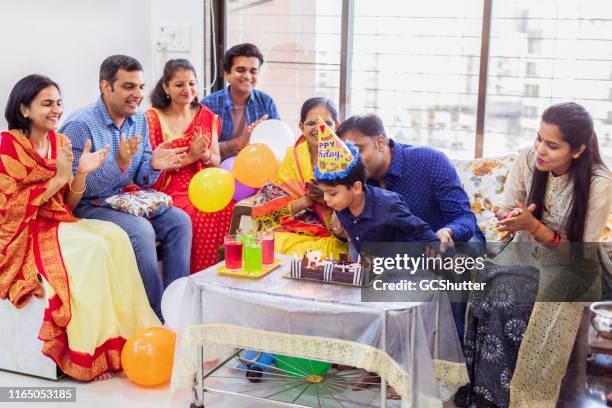 famiglia che festeggia il compleanno del bambino - parents children blow candles asians foto e immagini stock