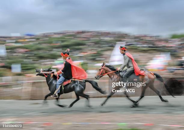 People wearing traditional clothing compete in a horse race during the Torch Festival in Zhaojue County on July 24, 2019 in Liangshan Yi Autonomous...