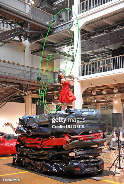 Violinist Anna Zlotovskaya, who is part of the art work, performs on the installation "Crying Cars" by German artist HA Schult during a preview of...
